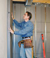 Insulated basement wall panels being placed against a concrete foundation wall in South Portland