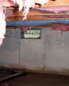 Maine crawl space with vents, showing mold, rot, and fiberglass insulation dripping off the ceiling.