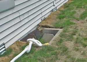 The ugly, old concrete window well of a Rochester crawl space