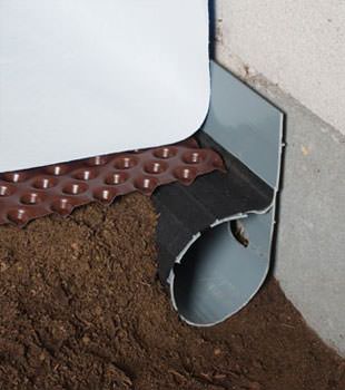 Closeup of a crawl space drainage system installed in Skowhegan
