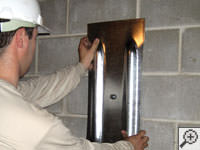 Mounting a foundation wall plate for an earth anchor installation in Brunswick.