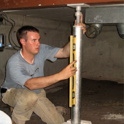 A contractor in Brunswick installing a crawl space jack post.