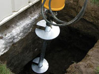 Installing a helical pier system in the earth around a foundation in Lewiston