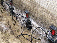 Using foundation push piers to lift a foundation during a repair in Biddeford.