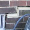 A closeup of a failed tuckpointing job where the brick cracked on a Conway home.