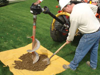 Auguring a hole in the earth for a foundation wall repair system in Auburn