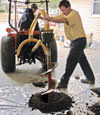 Digging a hole in the garage floor to make room for a wall anchor installation in Kennebunk, Maine