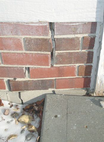 Severe street creep damage to a garage wall outside a Old Town home