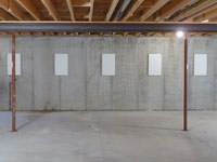 A repaired basement wall with foundation wall anchor covers installed in South Portland.