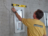 Positioning a wall plate cover on a foundation wall in Waterville.